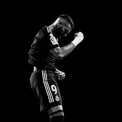 a man in black and white kicking a soccer ball