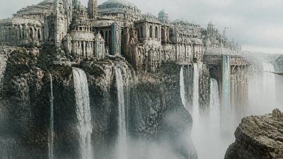 a cliffside city with waterfalls cascading into a misty canyon, wide establishing shot, no people, no text