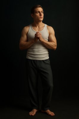 a man in a tank top standing with his hands folded