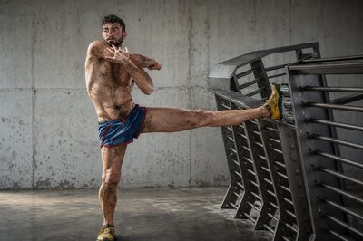 a man with no shirt is kicking a soccer ball
