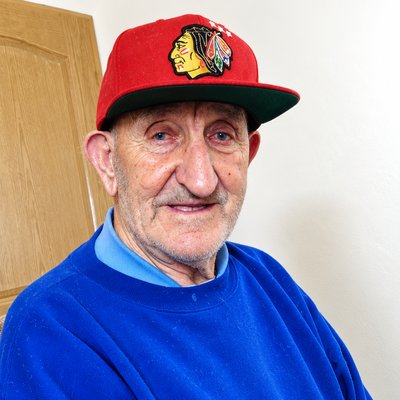 an older man wearing a red hat and a blue shirt