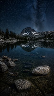 a tranquil mountain lake beneath a starry night sky, no people, no text