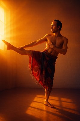 a man in a red skirt is doing a yoga pose