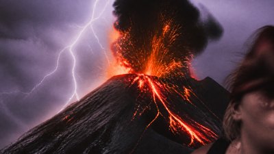 an erupting volcano with lightning strikes, dramatic wide composition, no text