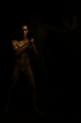 a man holding a pair of scissors in the dark