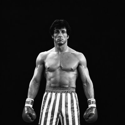 a black and white photo of a man wearing boxing gloves