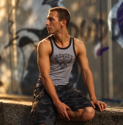 a man sitting on a wall with his legs crossed