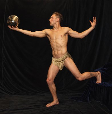 a man with no shirt is playing with a ball