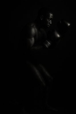 a black and white photo of a man wearing boxing gloves