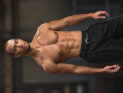 a man without a shirt is doing a trick on a skateboard