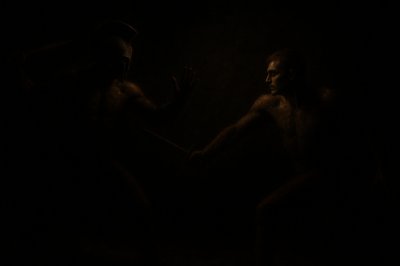 a couple of men standing next to each other in the dark