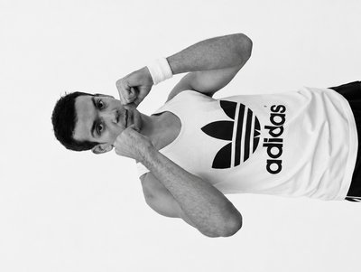 a man in a adidas t - shirt poses for a picture