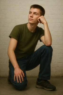 a man sitting on the ground with his hand on his head