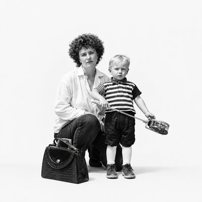 a woman kneeling down next to a little boy