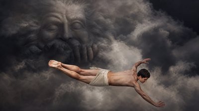 a man floating in the air in front of a painting