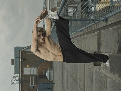 a shirtless man is holding a bottle in the air