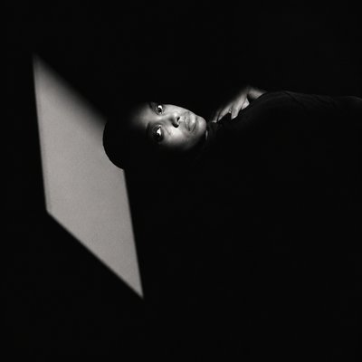 a person standing in a dark room with a laptop