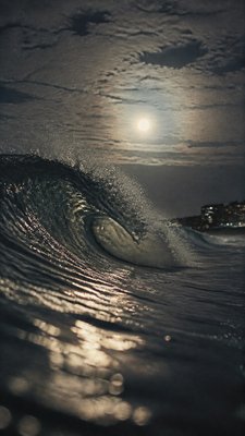 an ocean wave curling under moonlight, no people