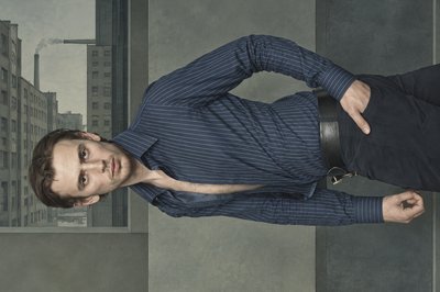 a man in a blue shirt is posing for a picture