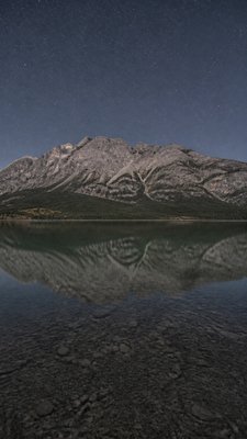 a tranquil mountain lake beneath a starry night sky, no people, no text