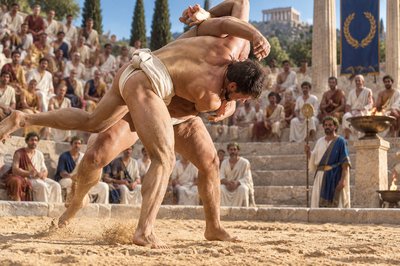 a man wrestling in front of a crowd of people