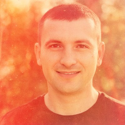 a man with short hair and a black shirt