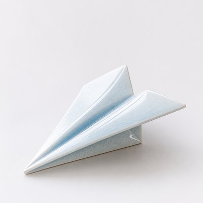 a paper plane, clean minimal composition on a plain background, no text