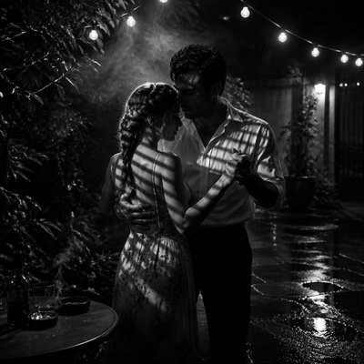 an original couple dancing under string lights in a garden at dusk: a man with short black hair in a linen shirt and a woman with braided red hair in a summer dress