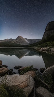 a tranquil mountain lake beneath a starry night sky, no people, no text