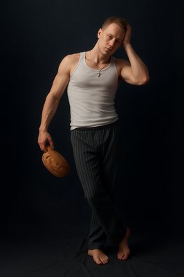 a man in a tank top is holding a baseball