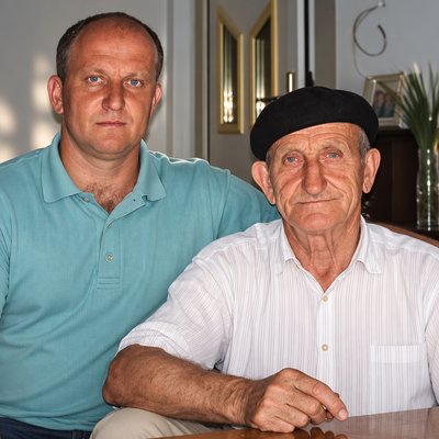a man sitting next to another man at a table