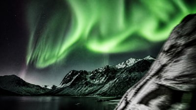 a flowing aurora over snowy peaks, wide sweeping composition, no people, no text
